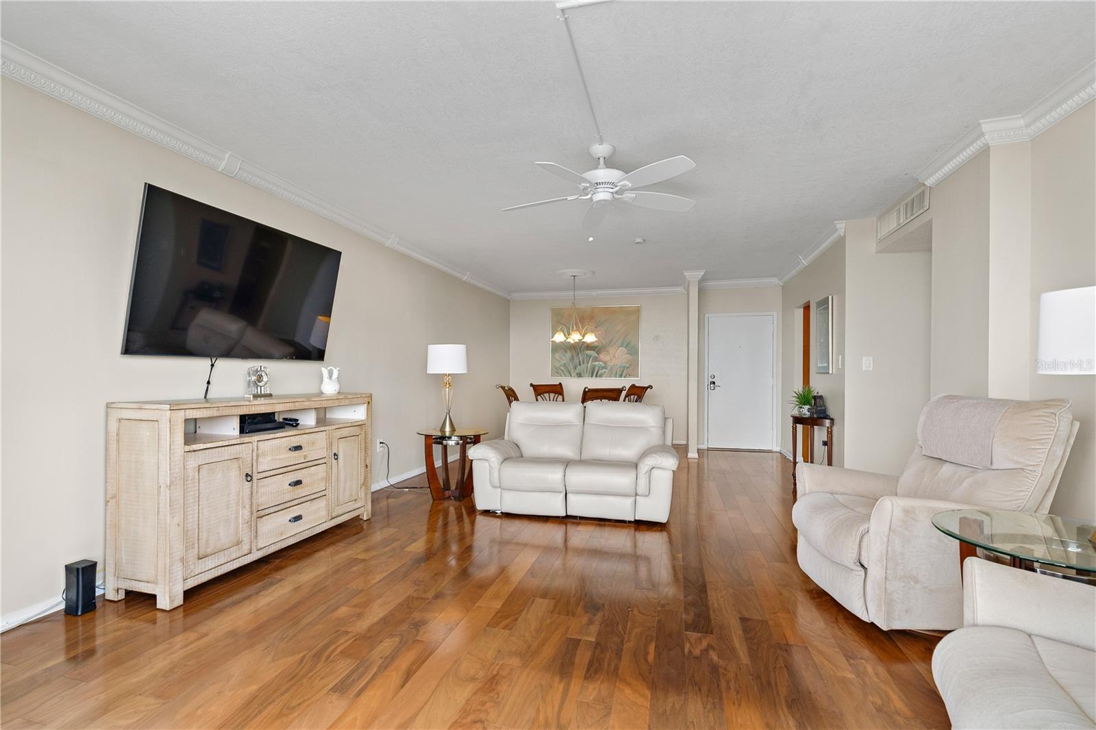 The spacious Living Room has decorative crown molding and wood flooring