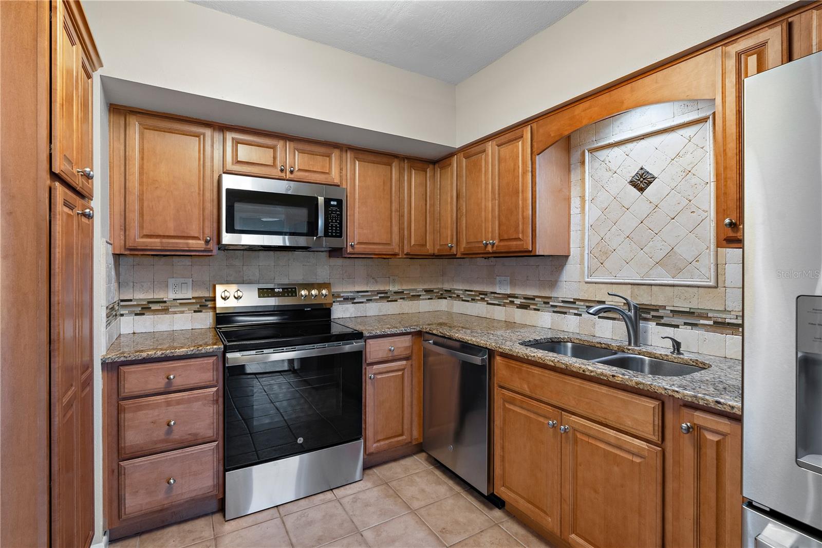 This wonderful kitchen has granite counter tops, tumbled marble backsplash and brand new appliances.