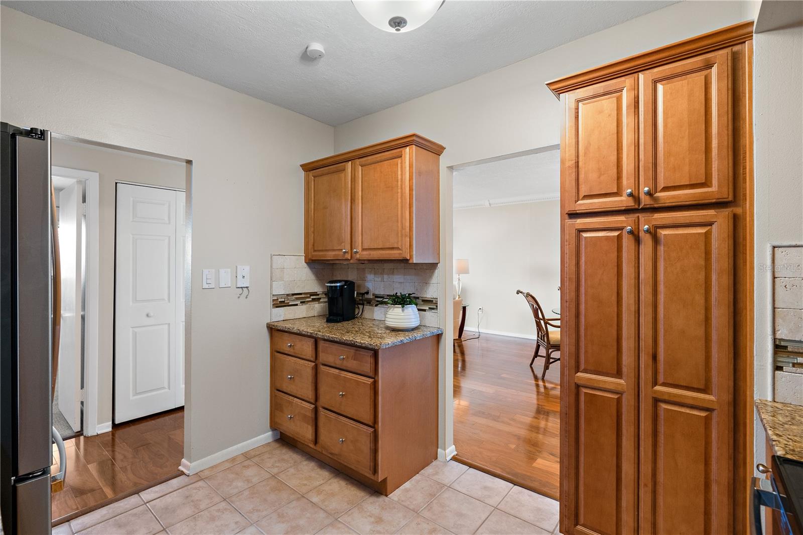 The kitchen has wood cabinets, a coffee bar and a closet pantry.