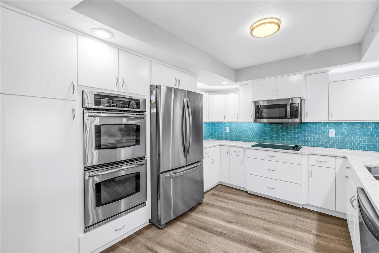 The kitchen has a double oven, microwave, refrigerator, cooktop and dishwasher.