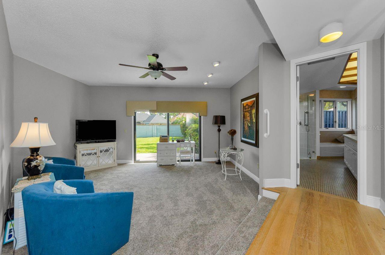 Primary Bedroom (staged as sitting room) and hall to spacious master bath...