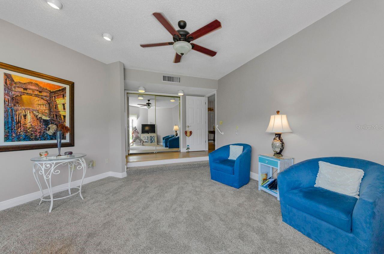 The primary bedroom has the large closet with mirrored door and room for a king bed, dressers and nightstands. Staged as a sitting room.