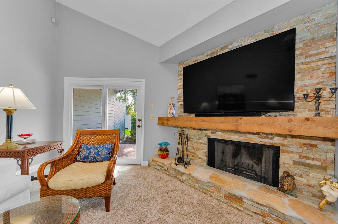 The living room fireplace, wood burning and the french doors to the back yard and patio. Perfect for plants and umbrella table...
