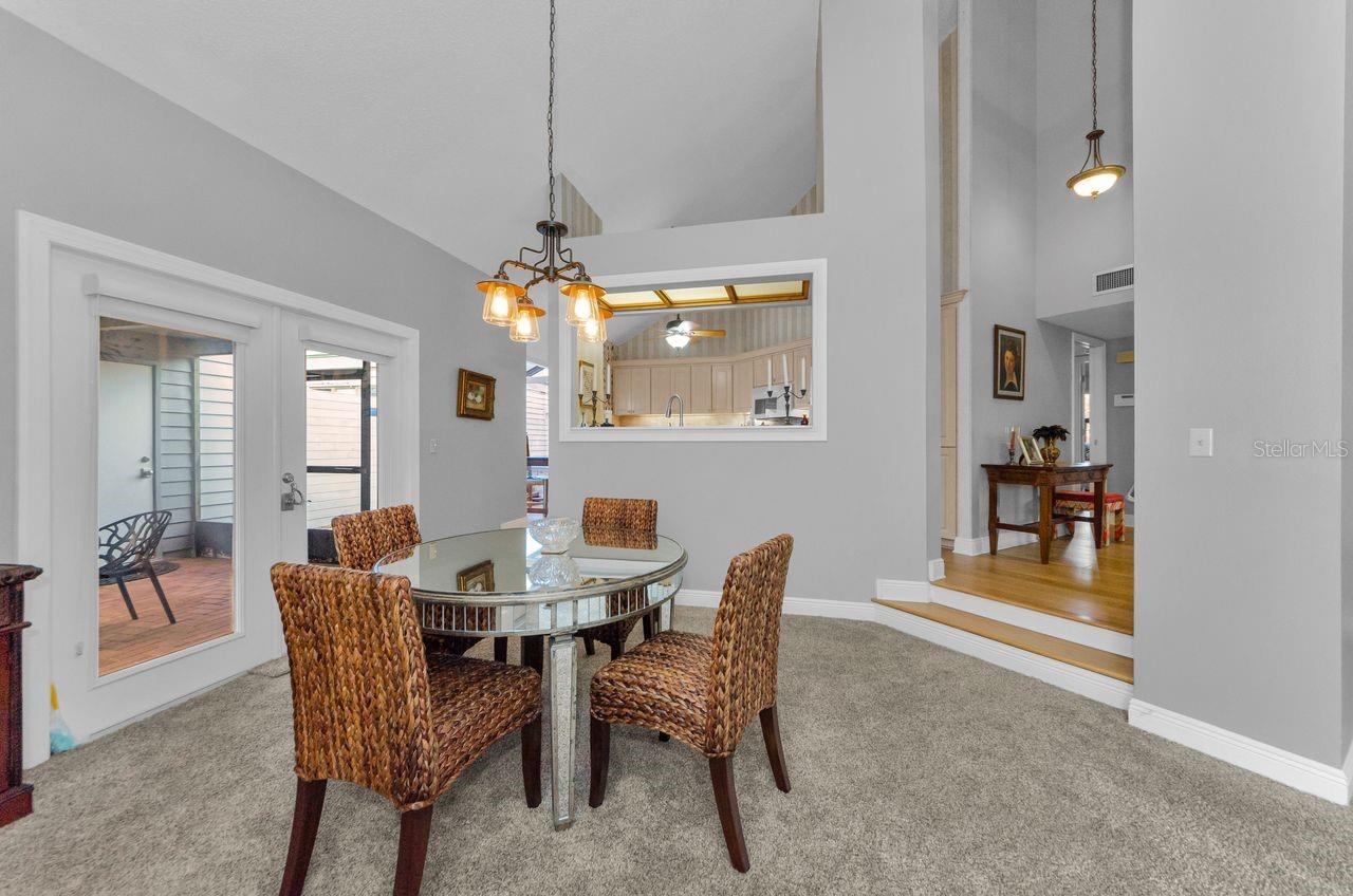 Dining room with view into the kitchen. To the left is the screened breezeway to the garage. To the right is the hallway to the bedrooms, baths and laundry closet.
