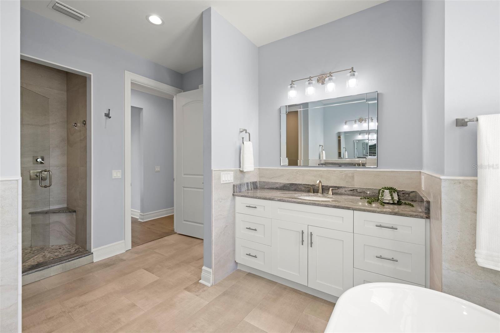 Primary bath has 2 vanities, a separate shower stall and separate comode