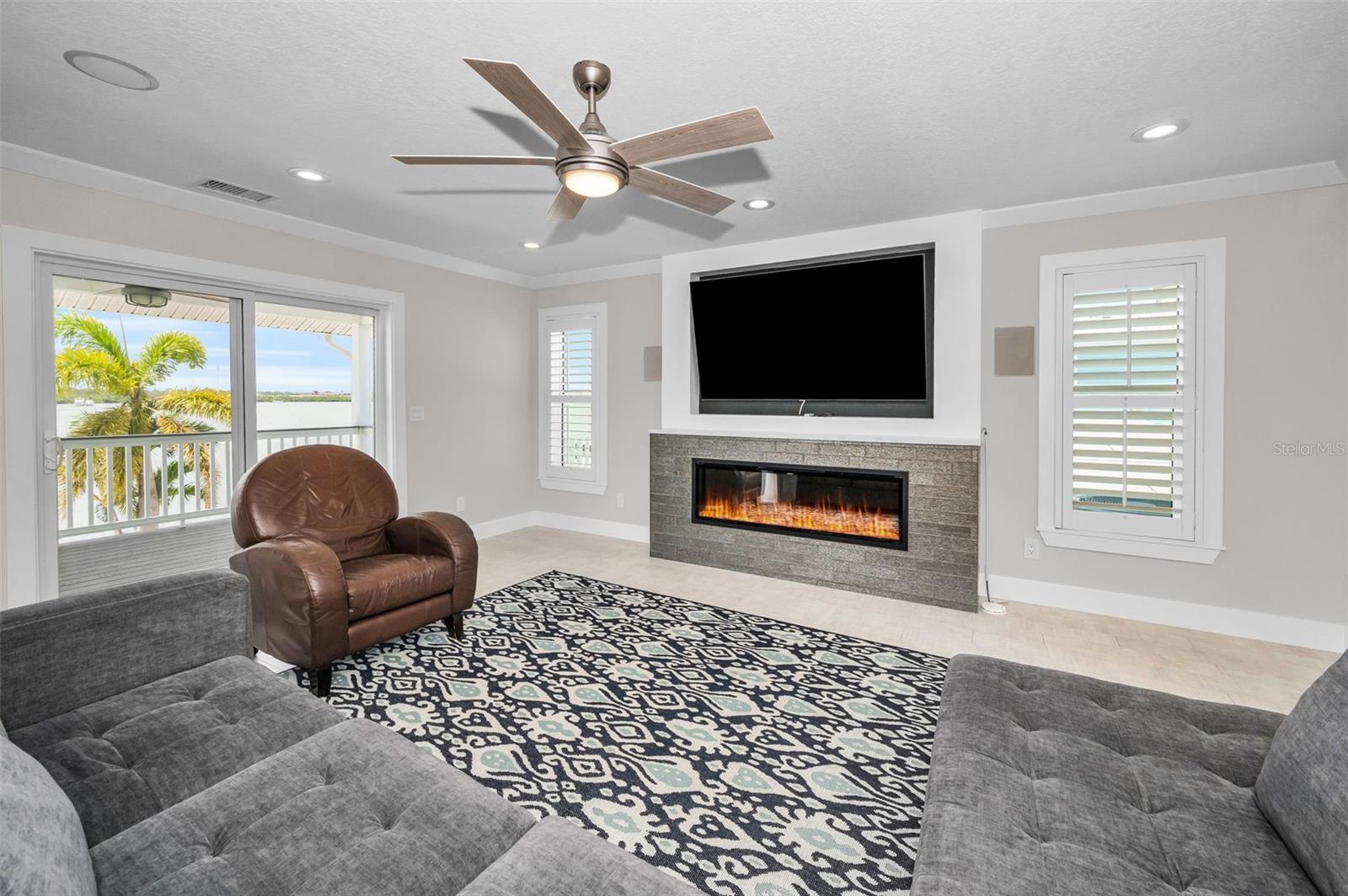Fireplace Focal Point: The modern hearth adds warmth and texture, balancing the coastal light with cozy ambiance