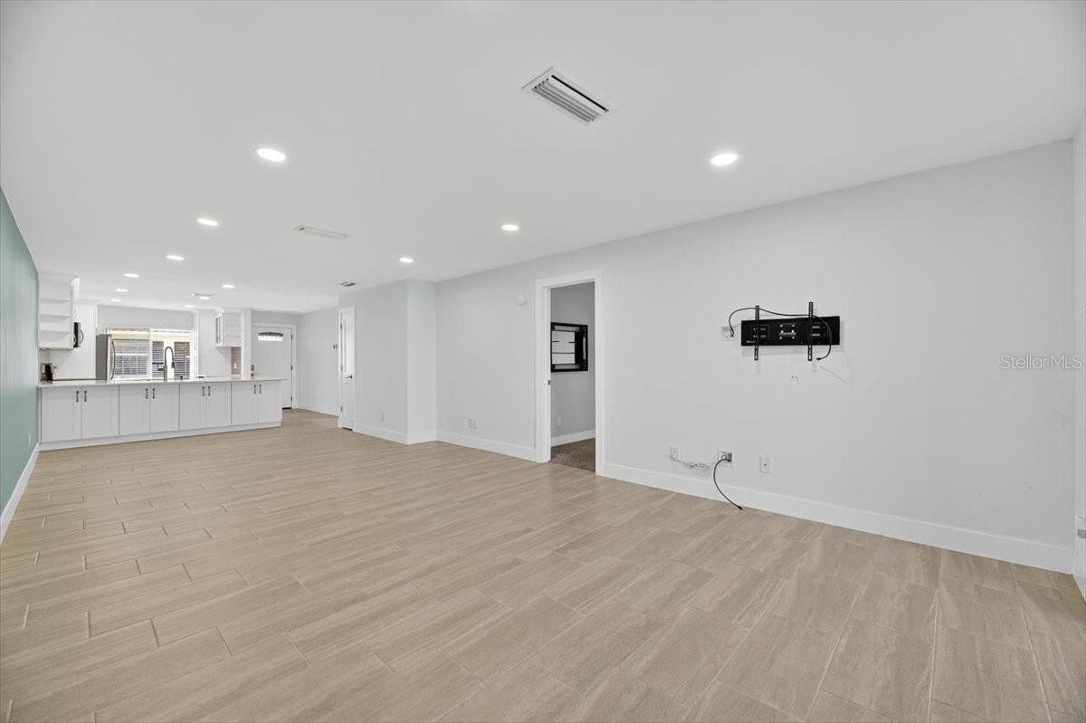 Living room view of tv and master entry.