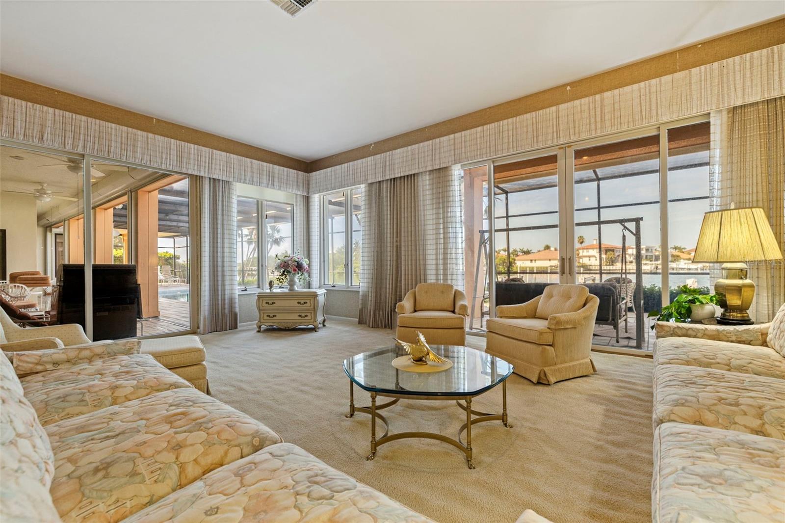 Family looking outside to the pool deck and water view
