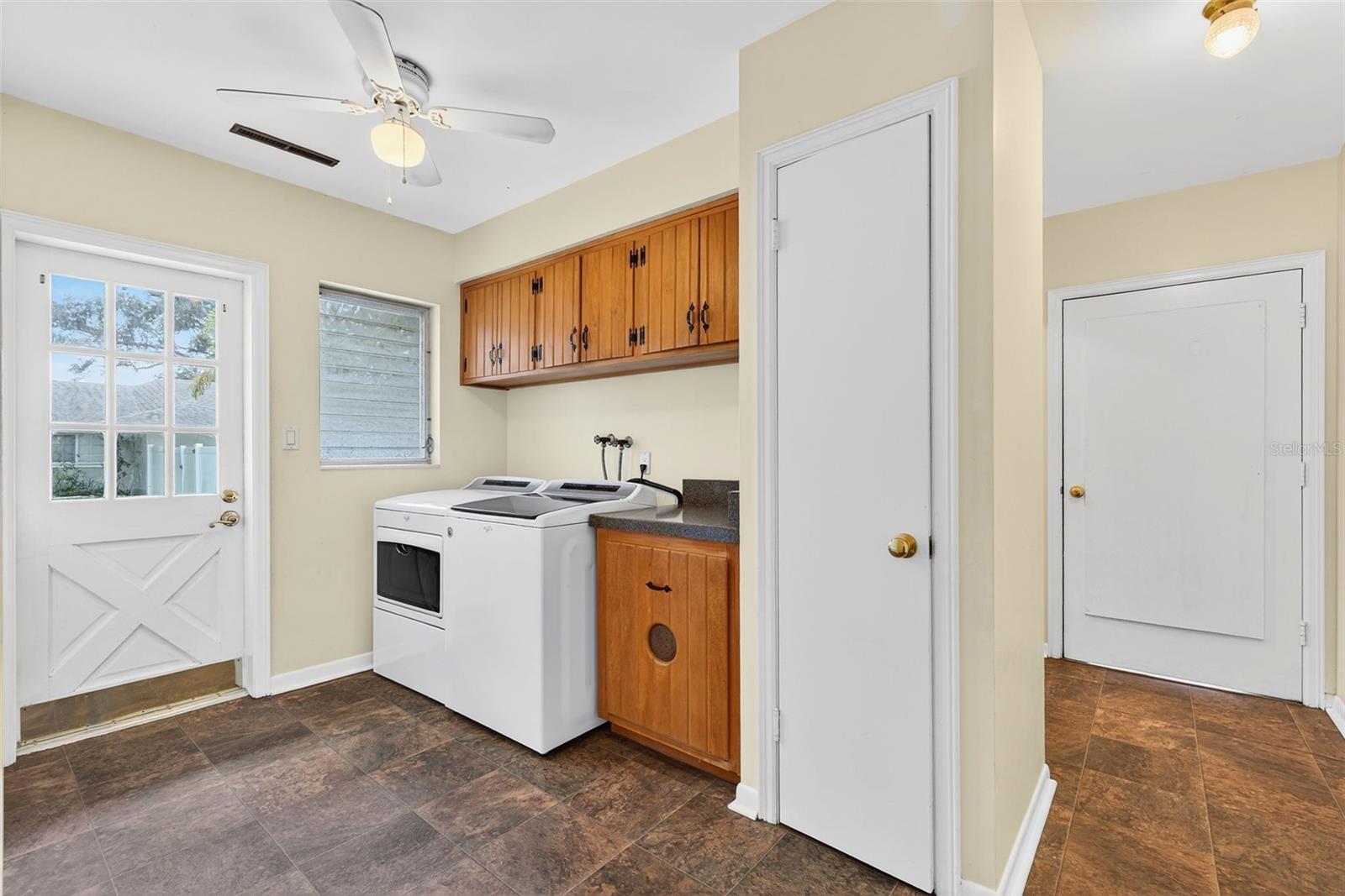 Laundry room next to the kitchen with a door leading outside