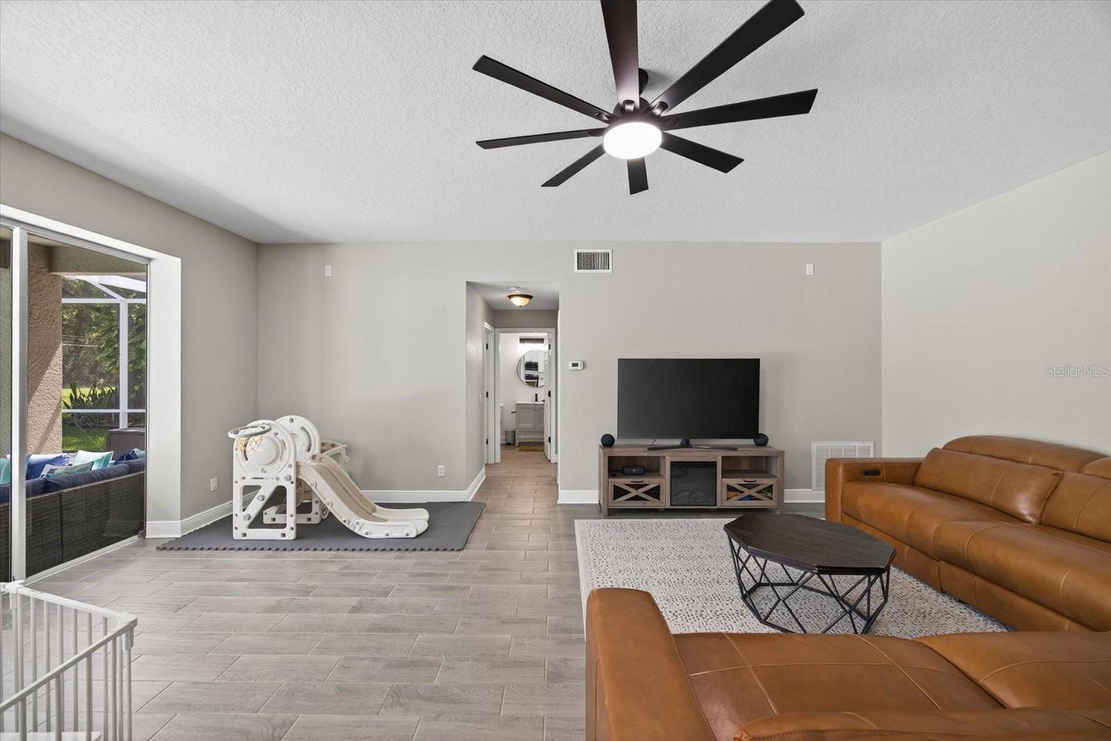 Family Room and Downstairs Hallway with Laundry Room, Bedroom, and Pool Bath