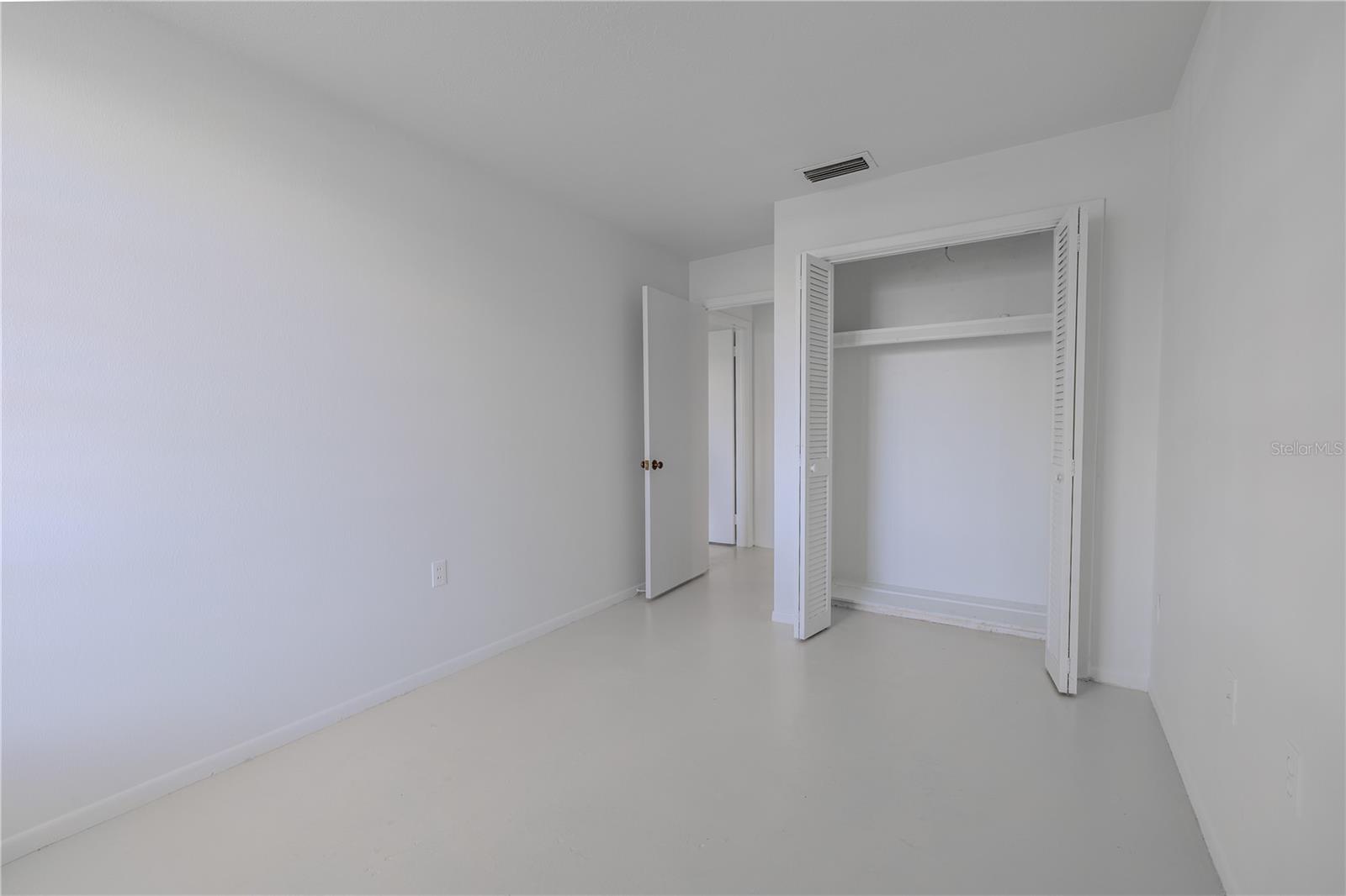 The freshly painted white walls and matching neutral flooring keep the space feeling clean, airy, and move-in ready. A roomy closet with louvered bi-fold doors provides ample storage, and there's plenty of wall space to accommodate a bed, desk, or dresser. Simple, versatile, and full of potential, this secondary bedroom is ready to suit your needs.