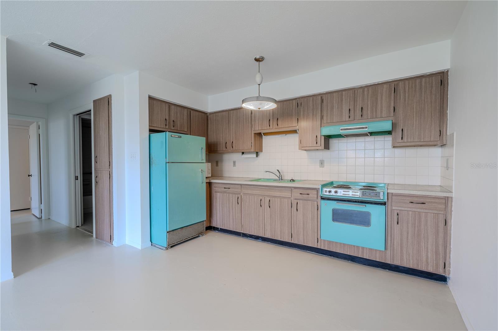 Classic wood-look cabinetry provides ample storage. Whether you're entertaining guests or simply enjoying a quiet evening at home, this open concept design offers comfort, flow, and functionality.