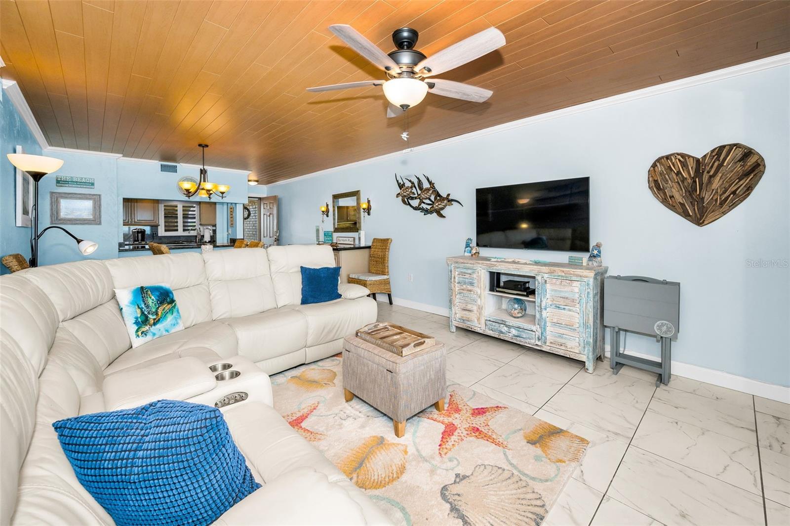 A vaulted canvas of beamed shiplap crowns the living space, channeling classic beach-house character with modern finesse