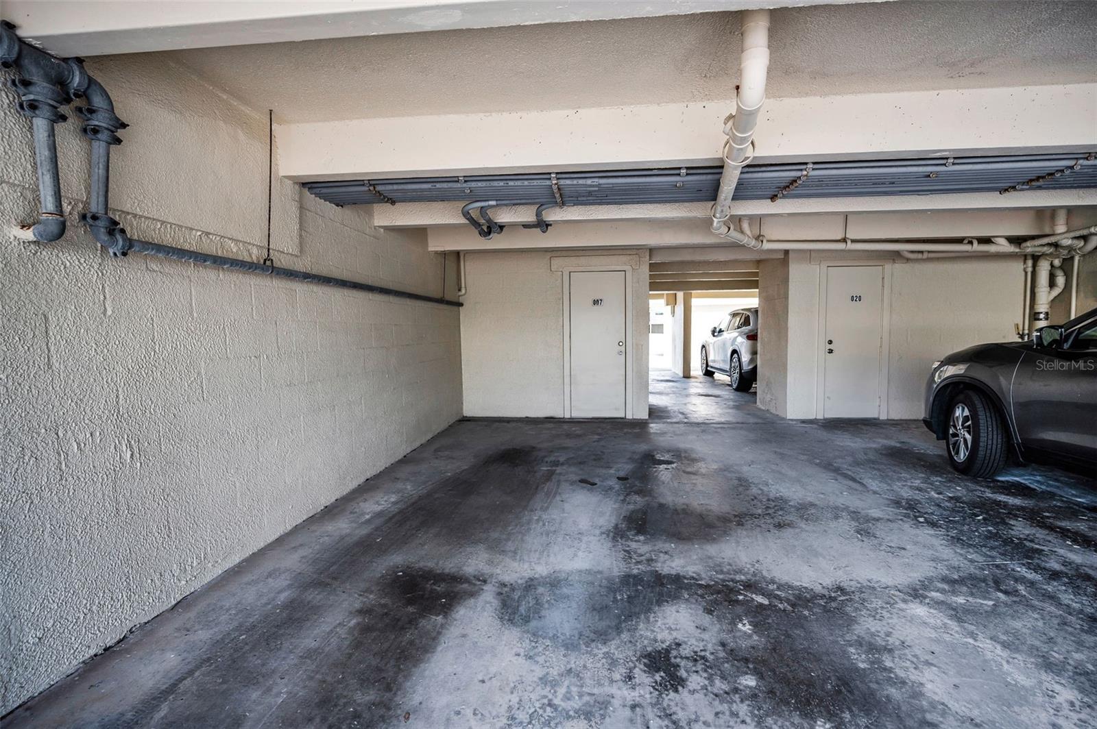 Large assigned under building parking space with storage closet