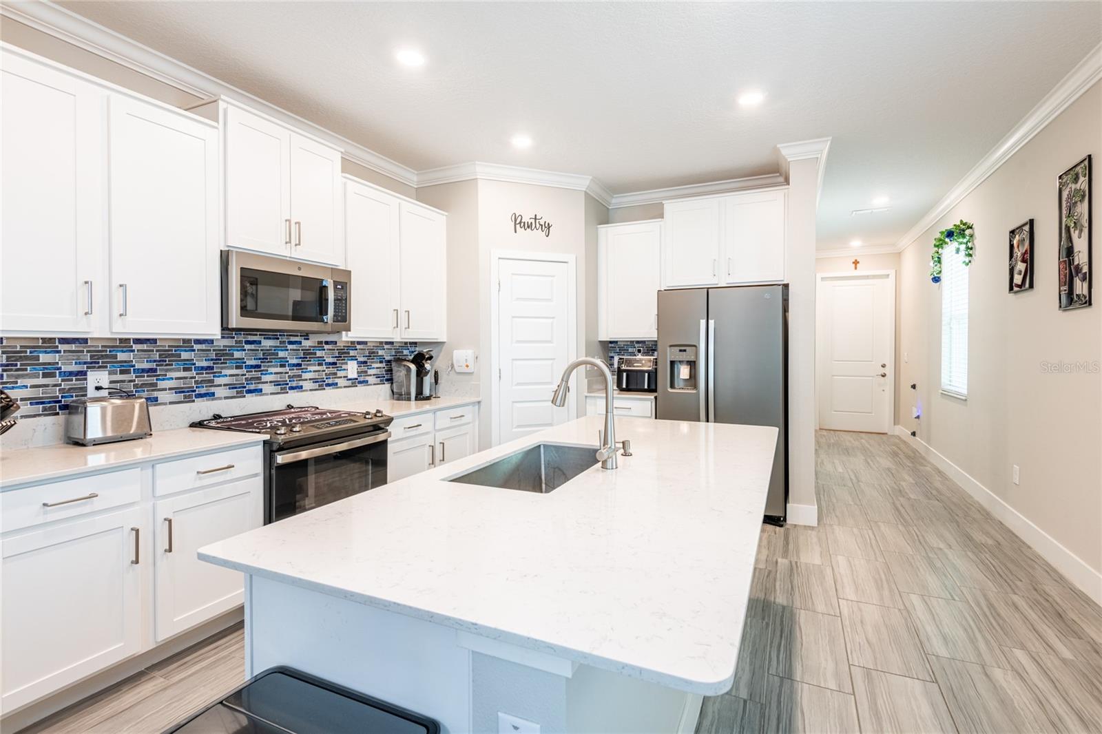 Wood look tile throughout the home.Designer backsplash. Home gets lots of natural light!