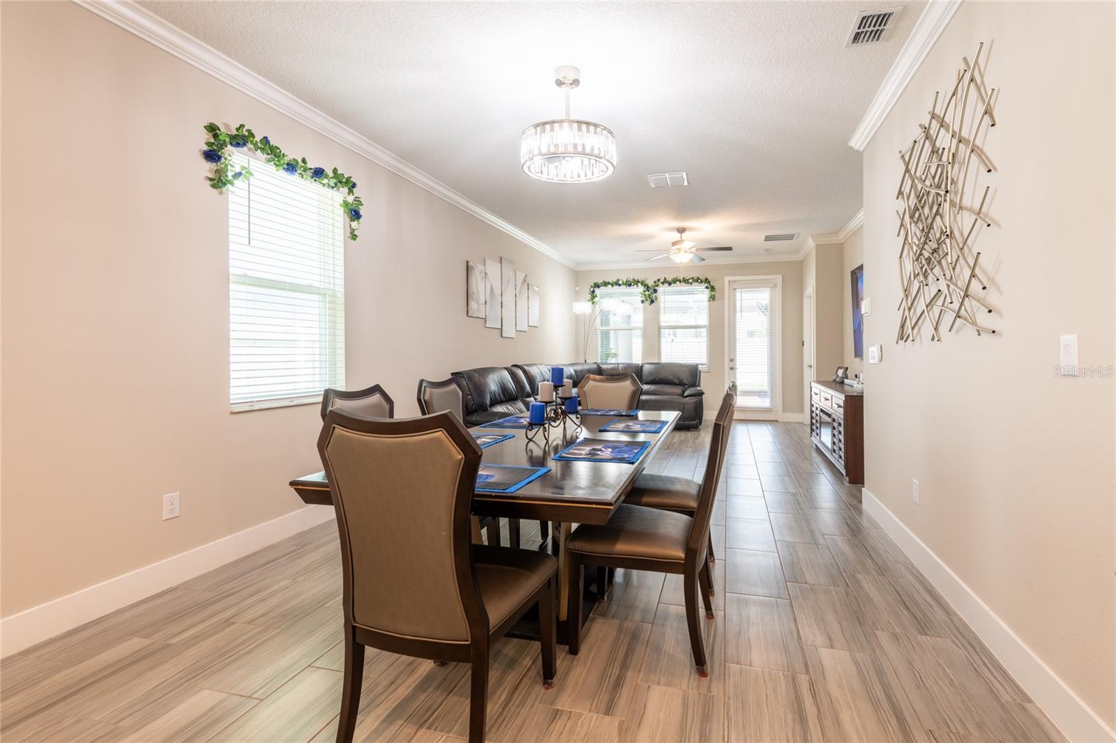 Spacious dining room with designer light fixture with fan.