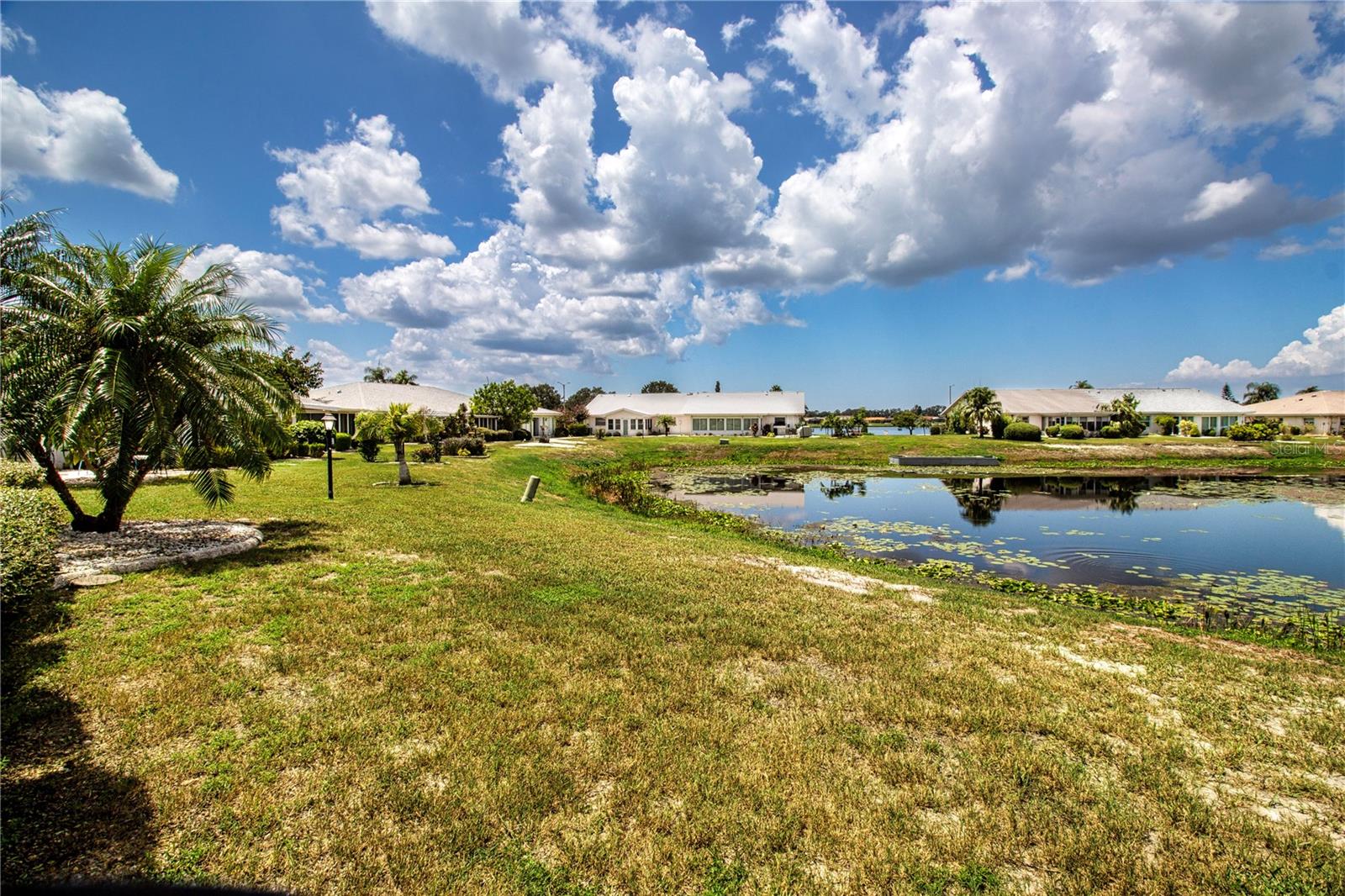 Pond view in back with peek view  of Simmons Lake in the distance