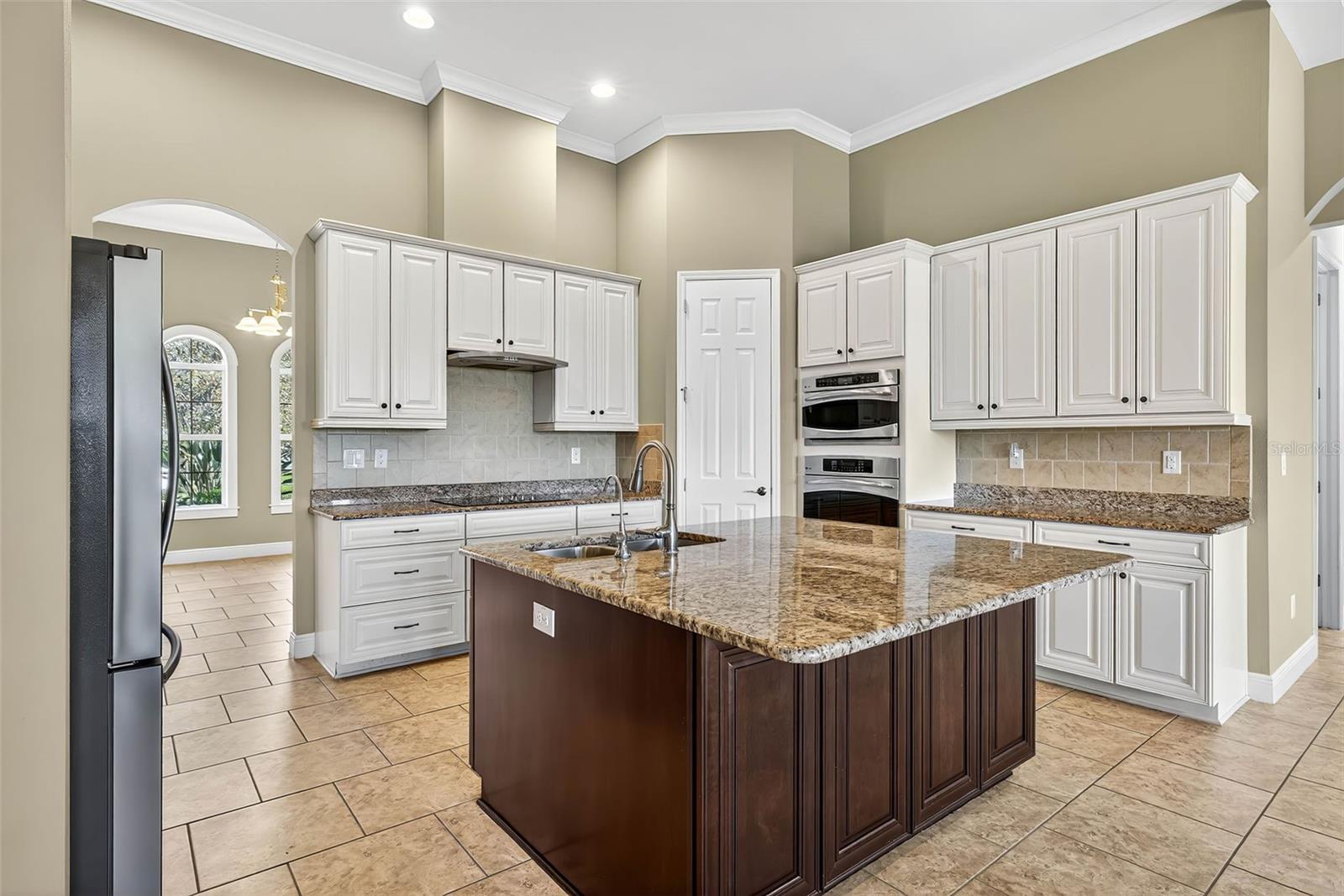 Kitchen with ornate cabinetry, stainless steel appliances, island for 4 & closet pantry.