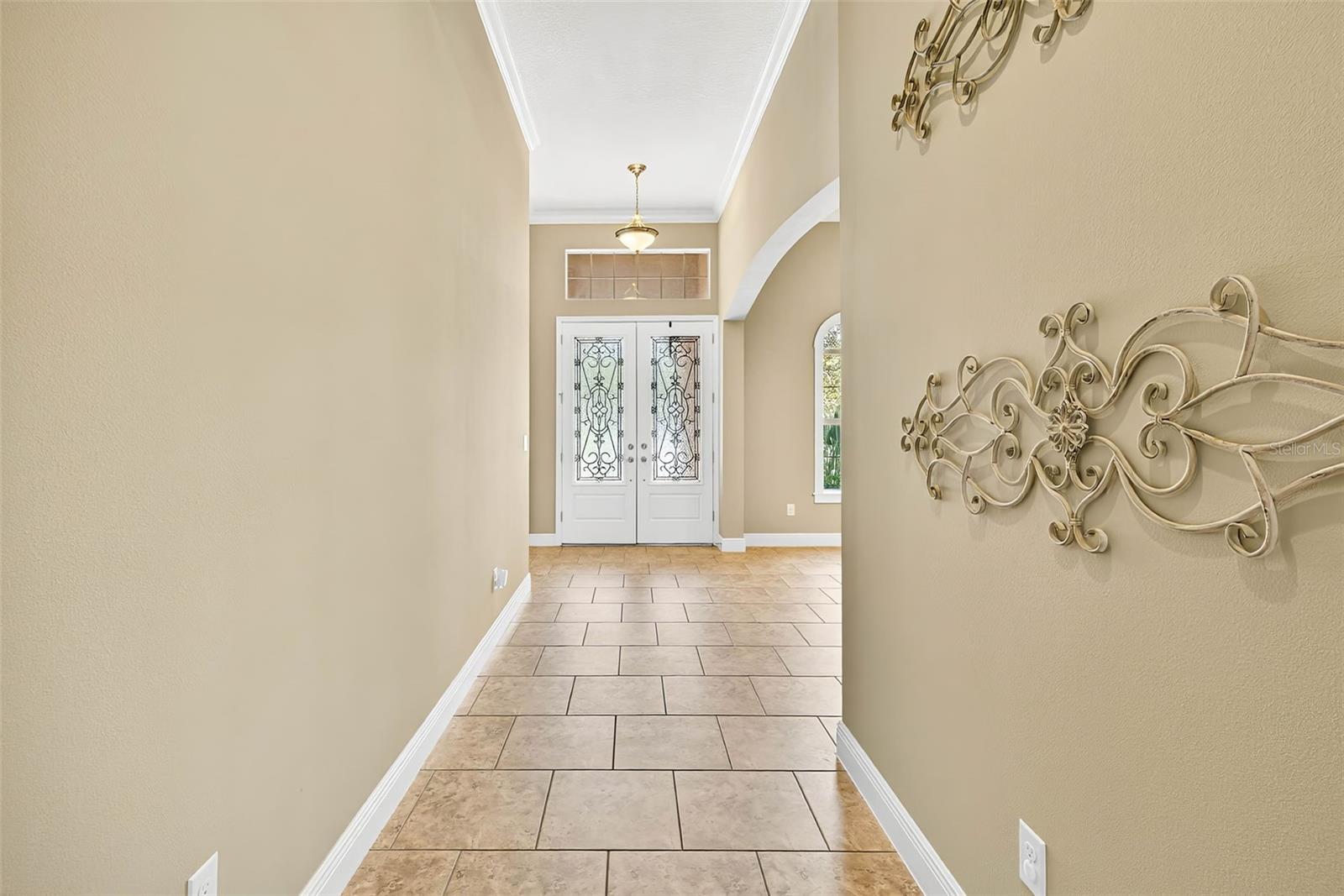 Bright entryway with high ceilings and double glass doors.