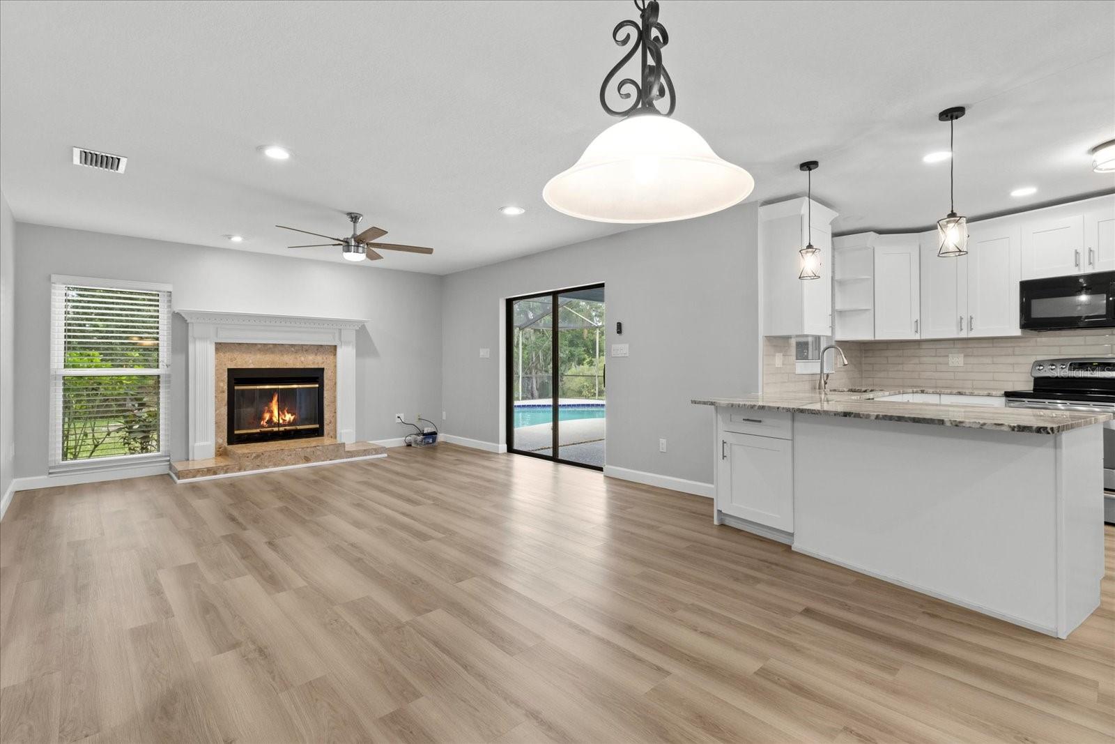 Dining area with kitchen on right and family room with views of pool and lake
