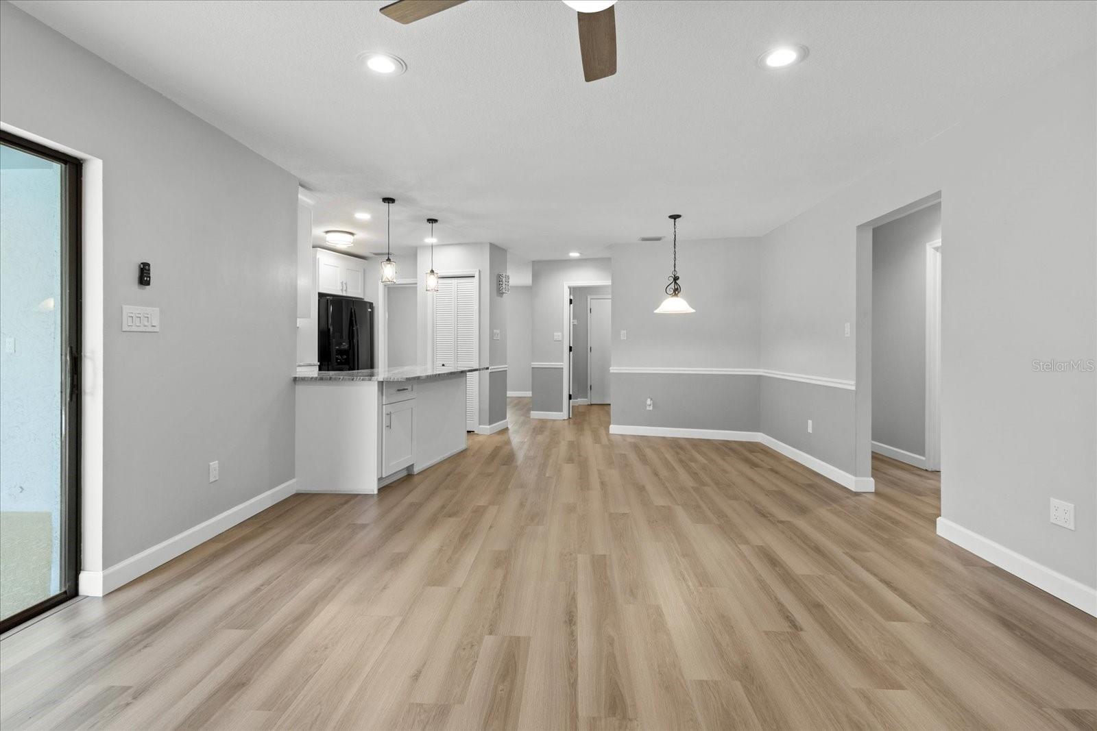 Family room View from fireplace toward kitchen and dining nook. Sliders to pool on left.