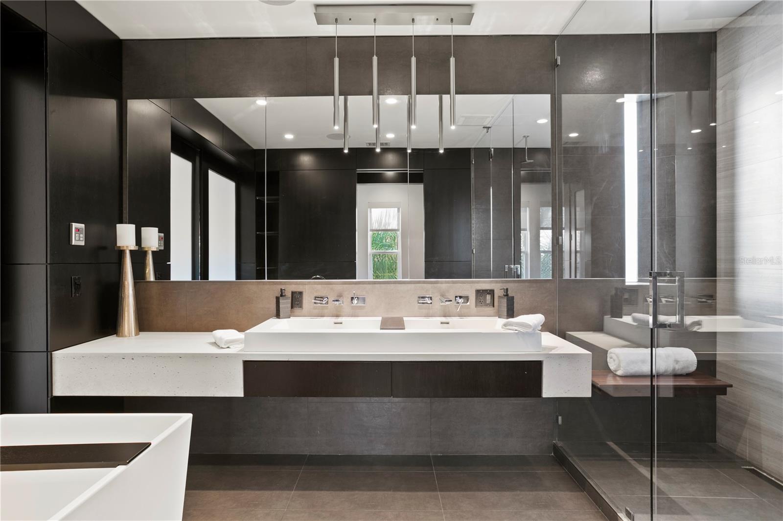 Oversized vanity with dual sinks and specialty lighting are just one of many spa-like features in this primary suite spa-inspired bathroom