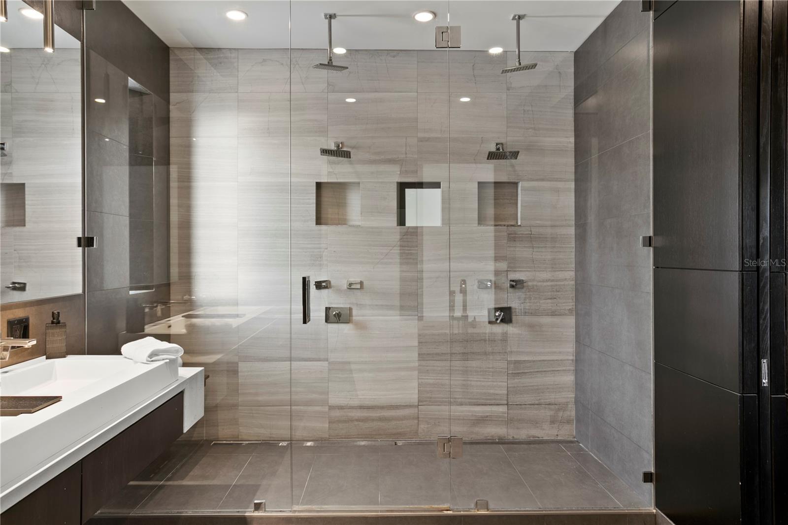 Spa inspired shower with 4 shower heads and views that extend to the water