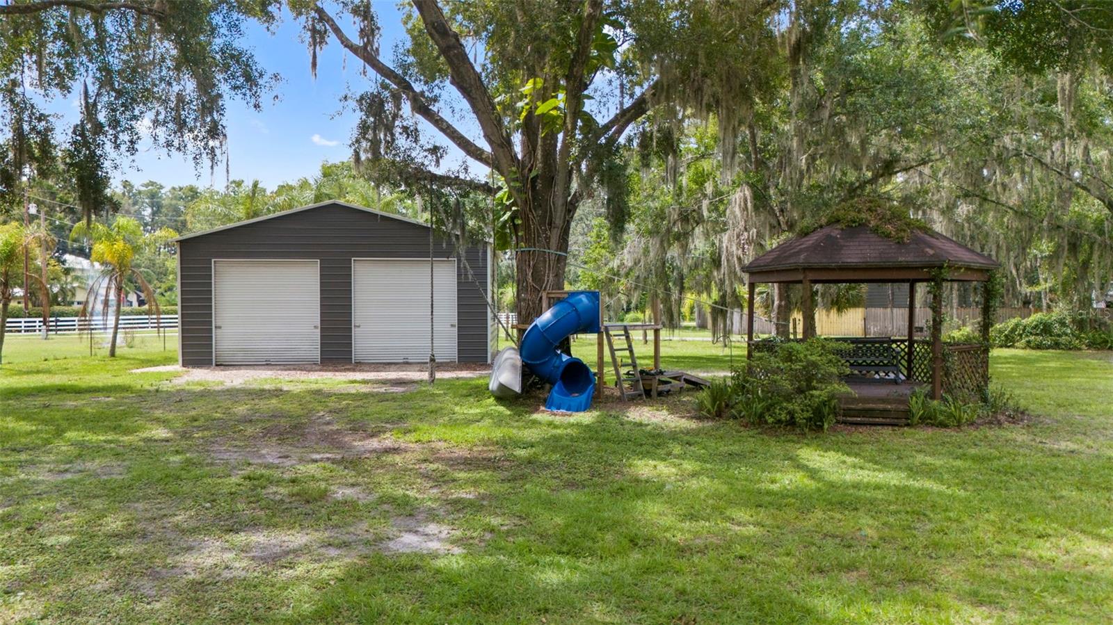 Shop, gazebo, playhouse and zip line in backyard