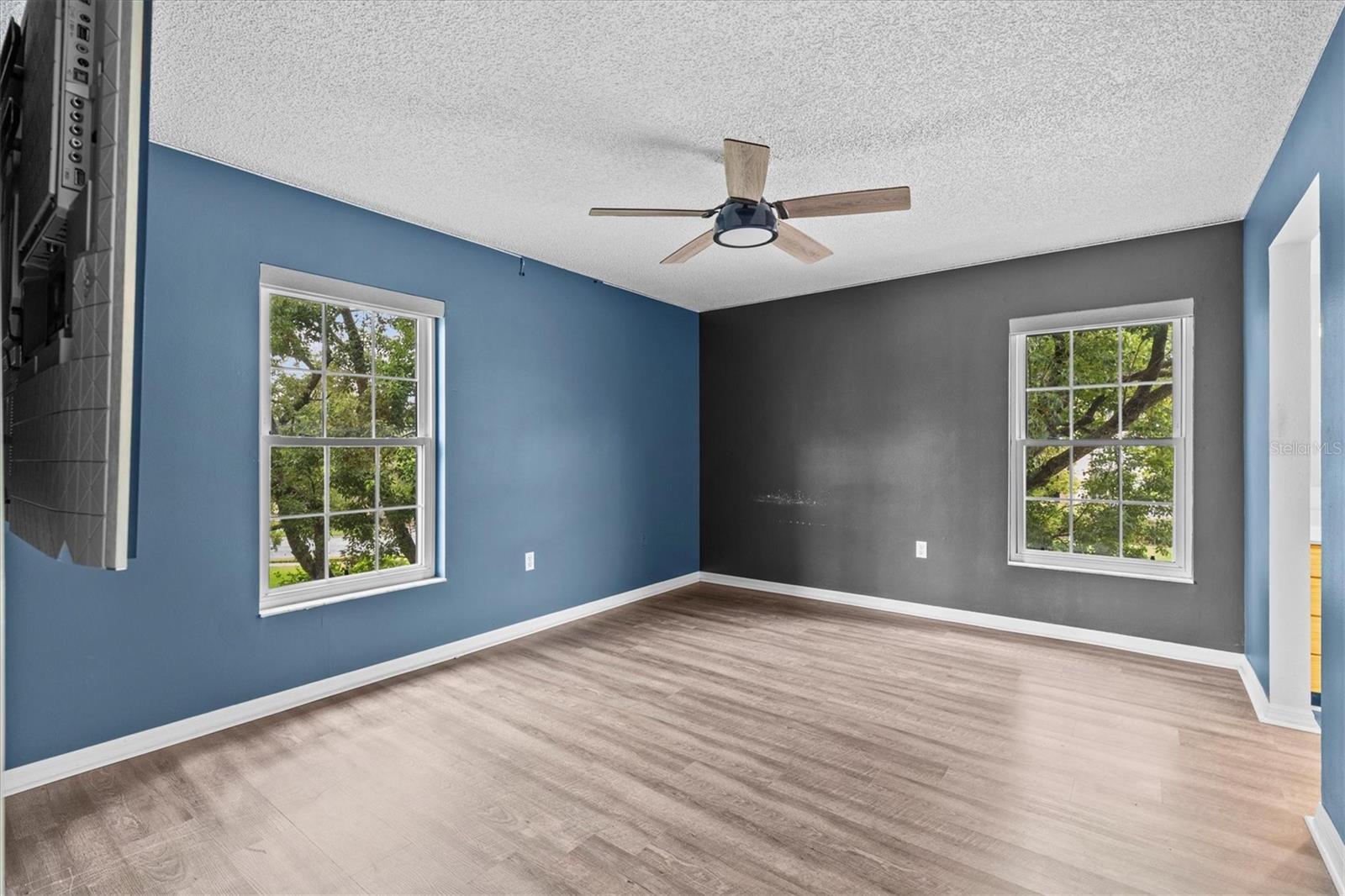 Primary bedroom with mounted TV that will be staying and en suite bathroom with walk in closet.
