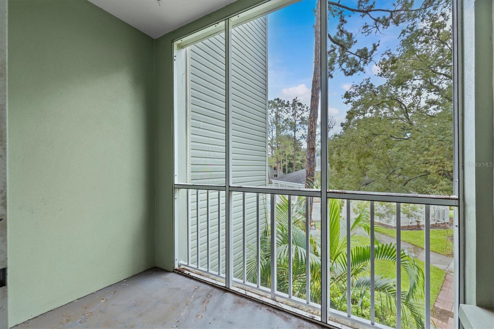 Private balcony area overlooking the pool and trees.