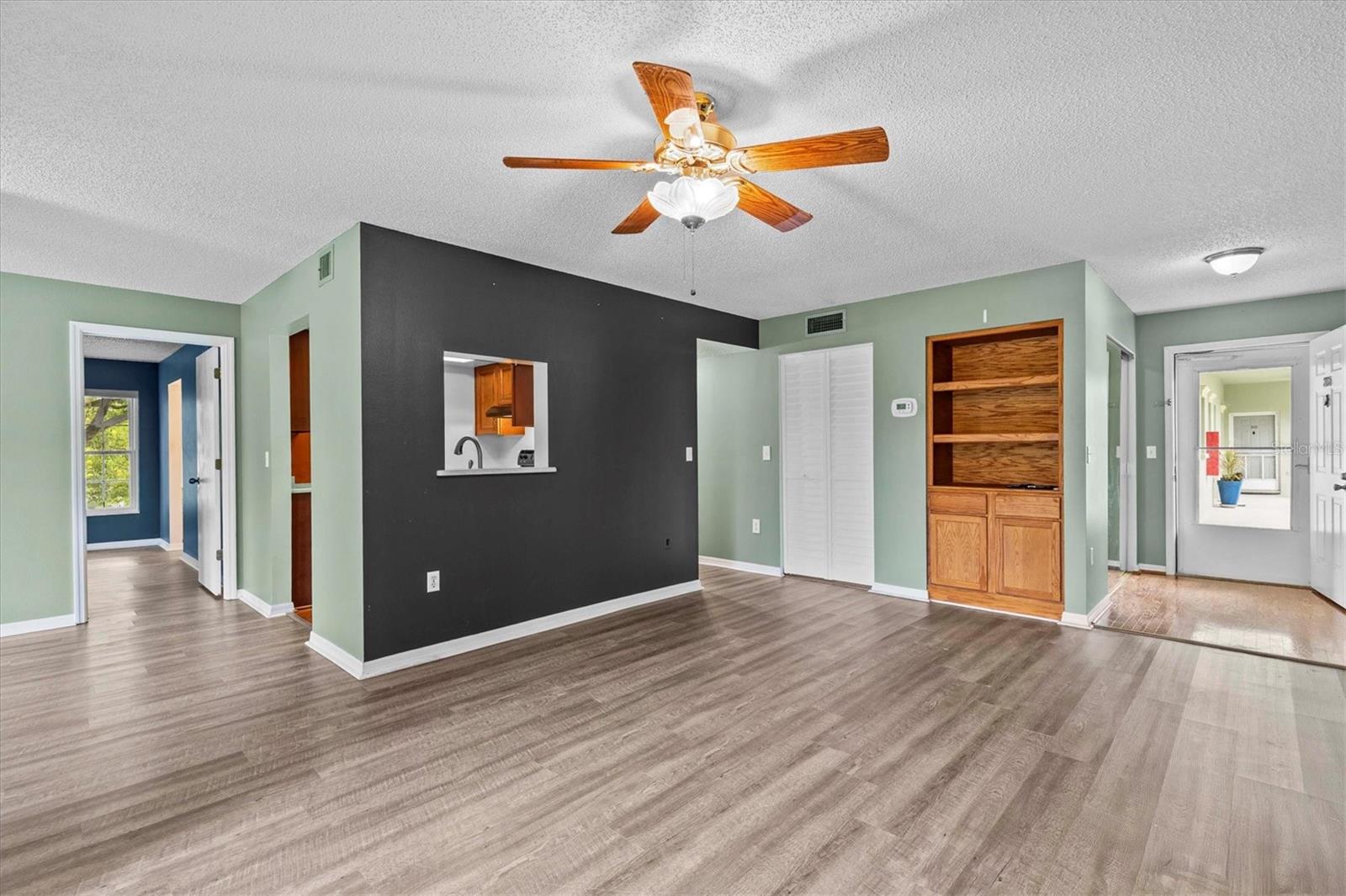 Living room area wit built in shelves and laundry room.
