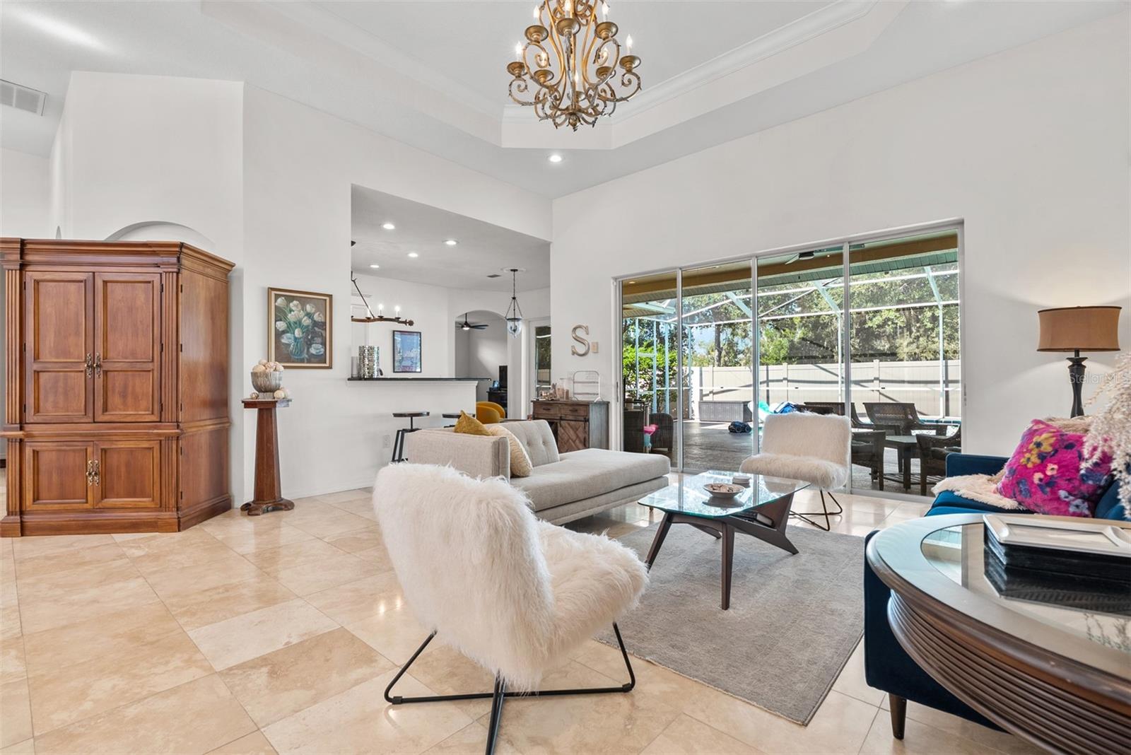 Glass doors open onto covered lanai pool area