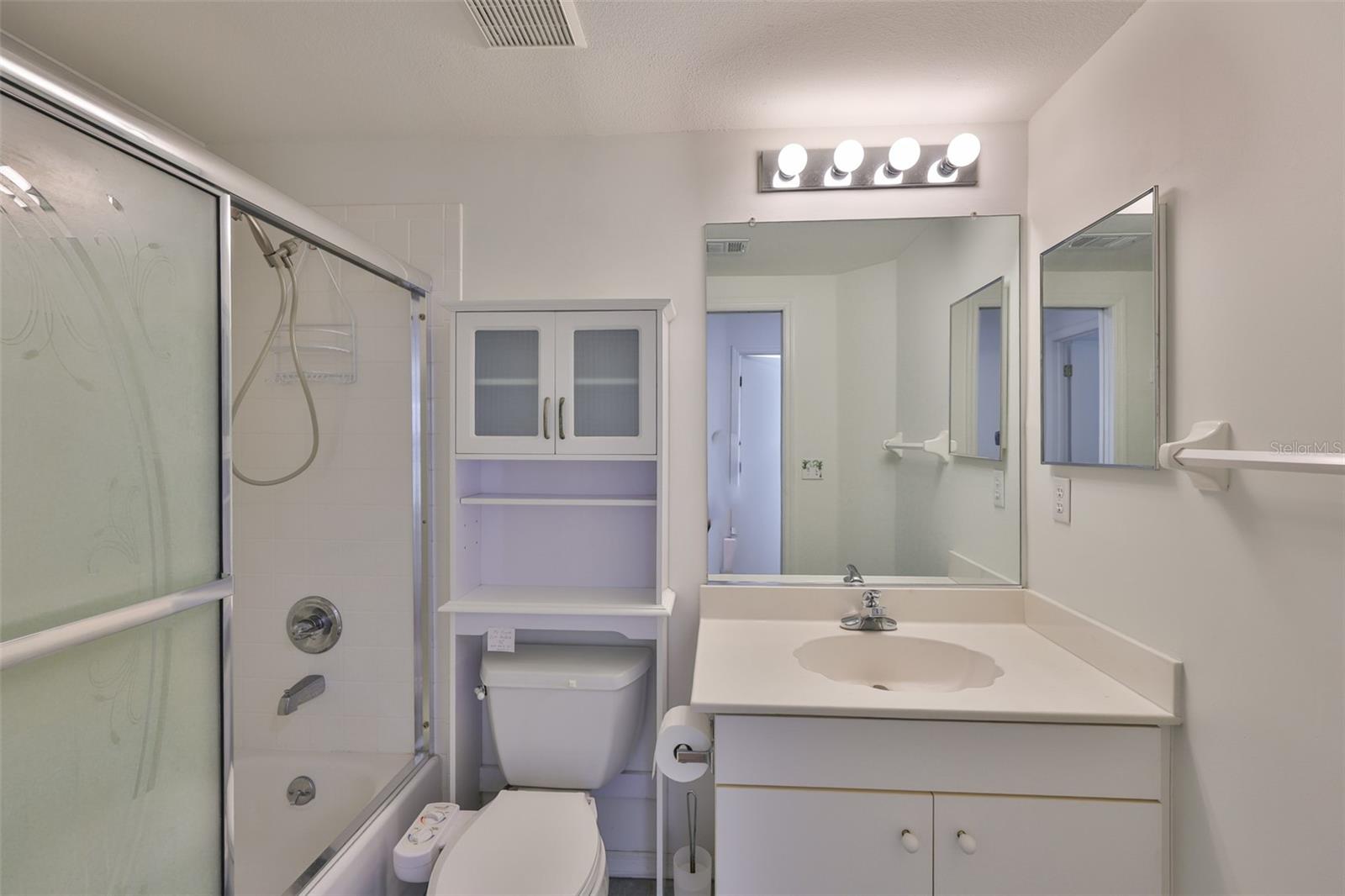 Bathroom 2 with bidet, shower tub combo with handheld and glass sliding doors.
