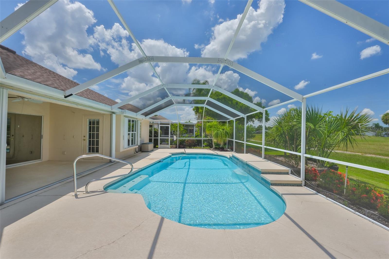 Covered lanai with ceiling fan and screened lanai for any weather. Lots of room to grill, lounge and entertain! Pool door to primary bedroom, pool with waterfall and automatic cleaner and garden/conservation view. Accordian hurricane shutters on all windows and sliders!