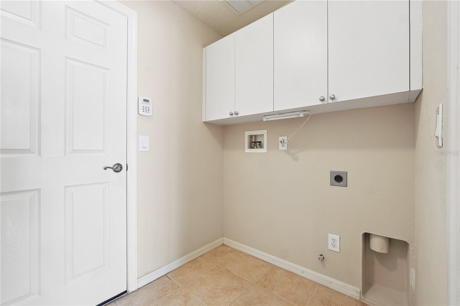Utility room with plenty of space for full size washer/dryer and extra shelving space.