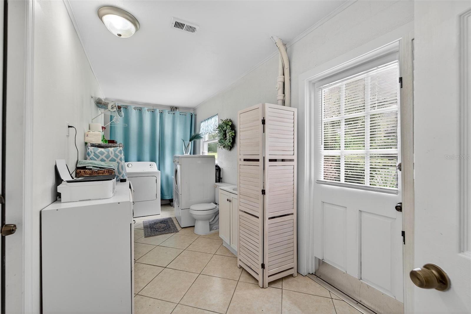 Bright laundry room with ample storage, and space for washer and dryer—designed for convenience and organization
