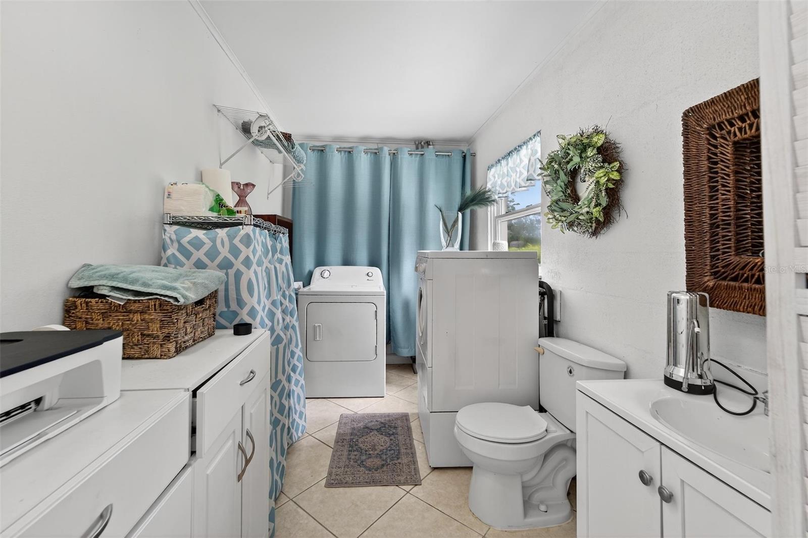 Laundry with easy access to both garage and to the outdoor patio.  The is also a half of bathroom