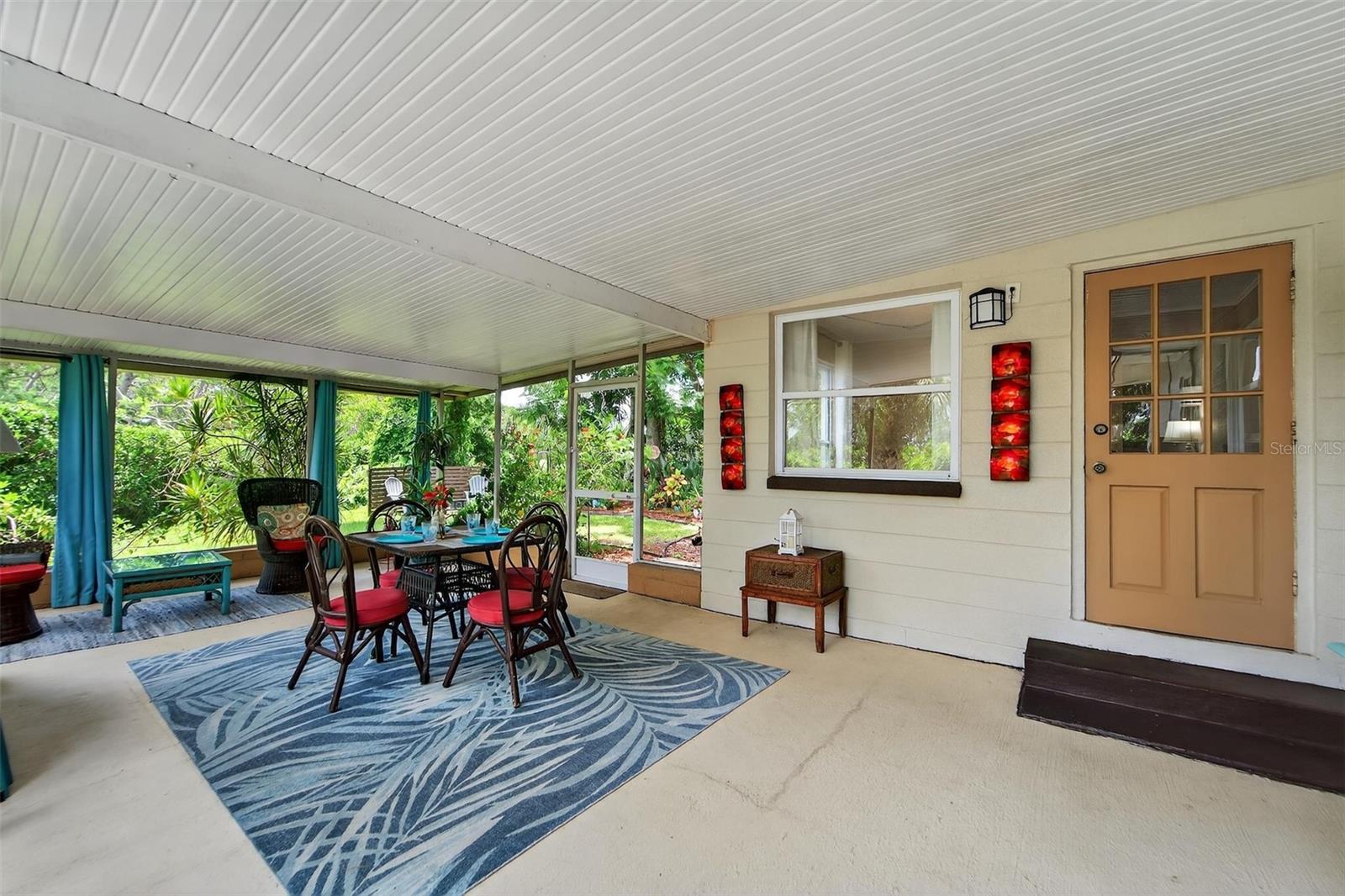 Covered lanai offering a cool, shaded spot to relax or entertain guests all while enjoying the beautifully mature landscaping