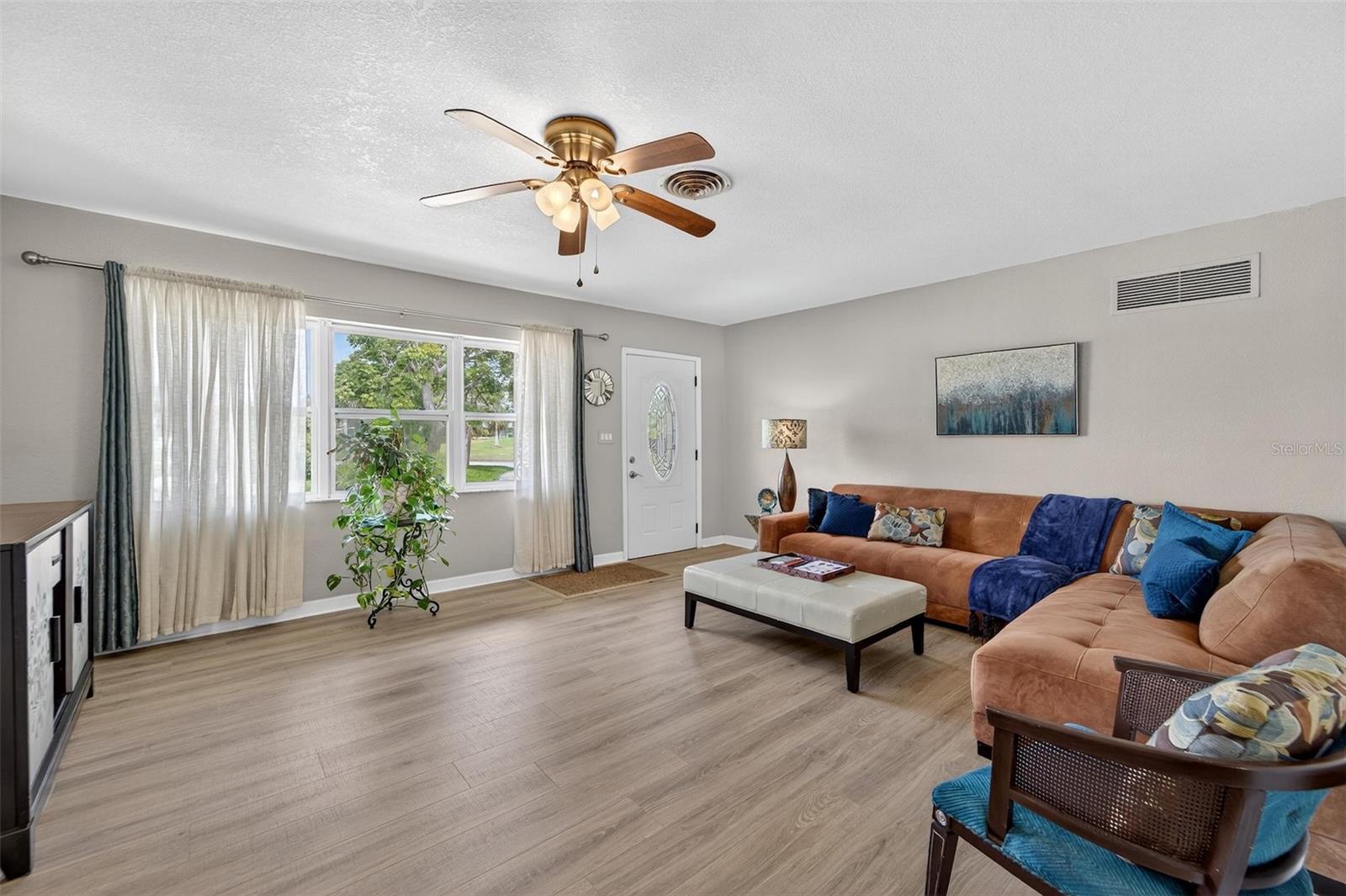 Step into a bright open living room with ample natural light pouring in through wide windows—creating a welcoming atmosphere perfect for family time or entertaining guests .jpg