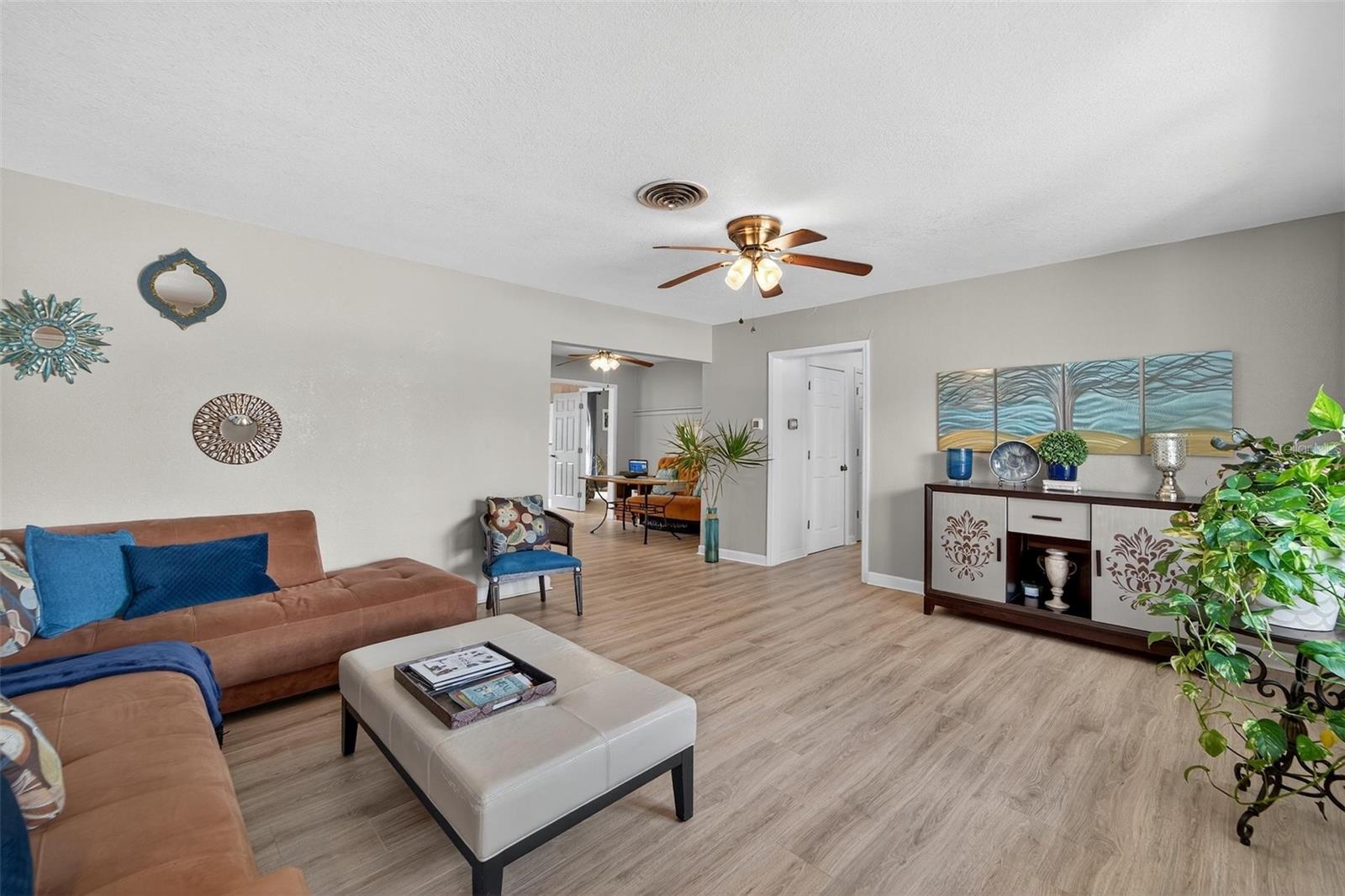 Open-concept living area with ample natural light pouring in through wide windows—creating a welcoming atmosphere perfect for family time or entertaining guests