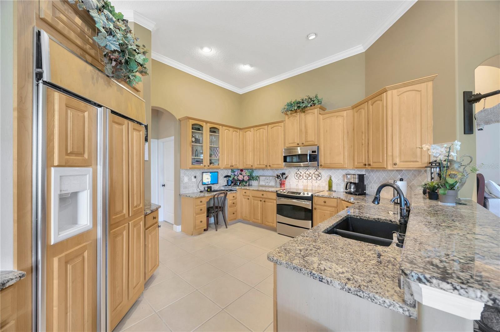 Kitchen with wood paneled refrigerator and stainless steel appliances