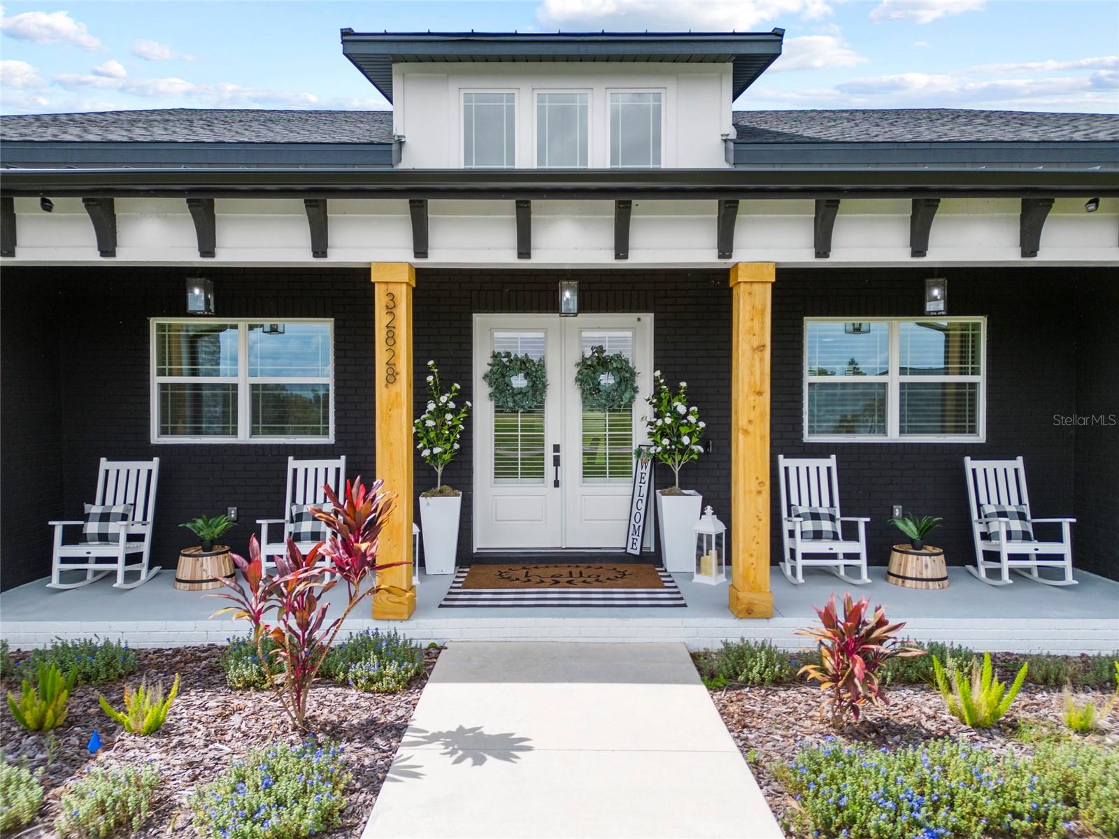 Gorgeous exterior with double french doors, brick, stone, board and batten and seamless gutters