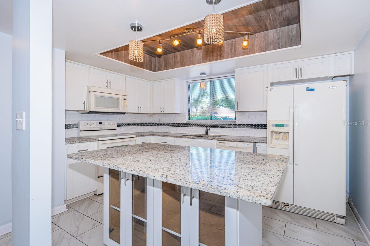 Pendant lights, spacious island with storage, a beautiful solid surface counter. tops!