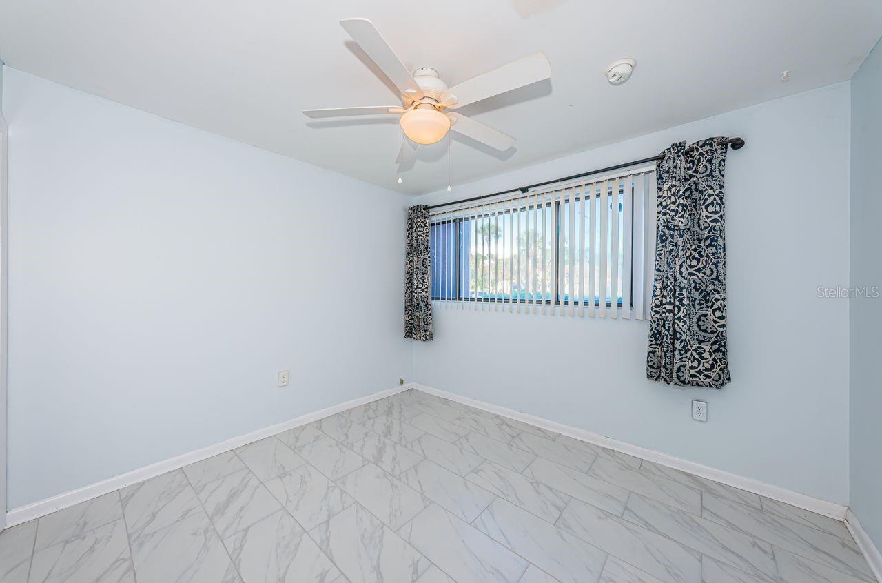Third bedroom with views of parking lot and across from the pool area.