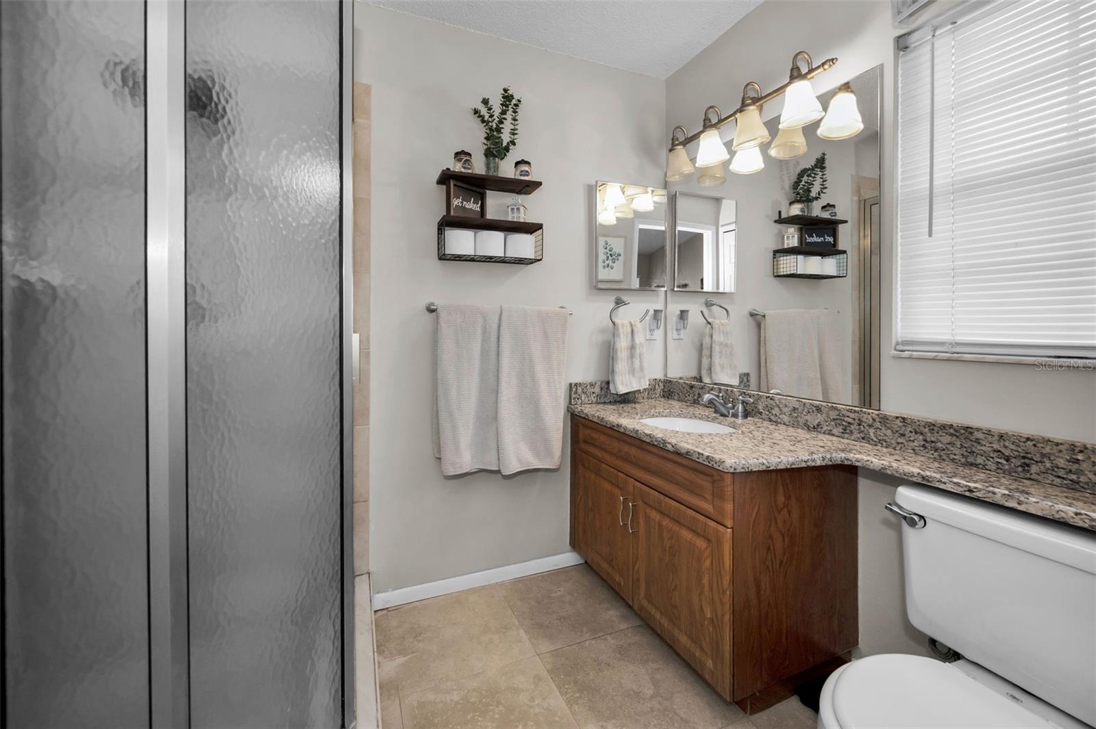ensuite bathroom with wood vanity, walk in shower