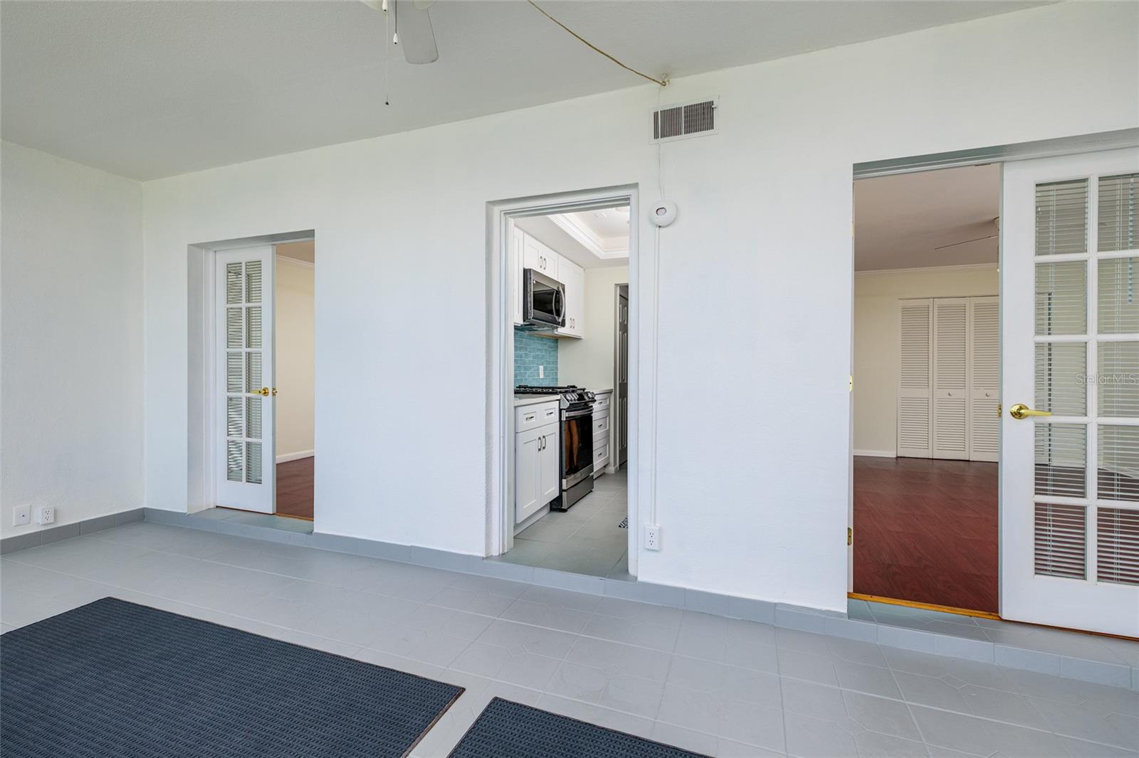 Florida room w/Primary bedroom on right, 2nd bedroom on left & kitchen in the middle.