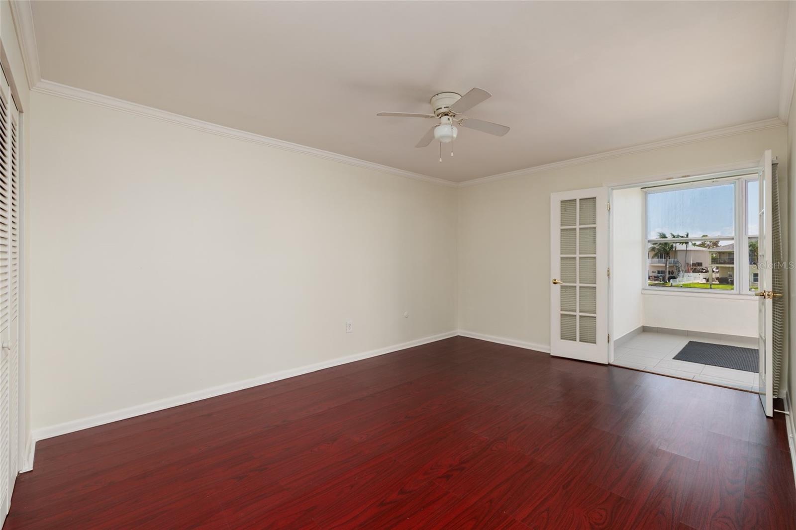 Primary Bedroom: Can accommodate a King size bed. Water views. French doors to Florida room. 11' x 15'. Crown Molding.