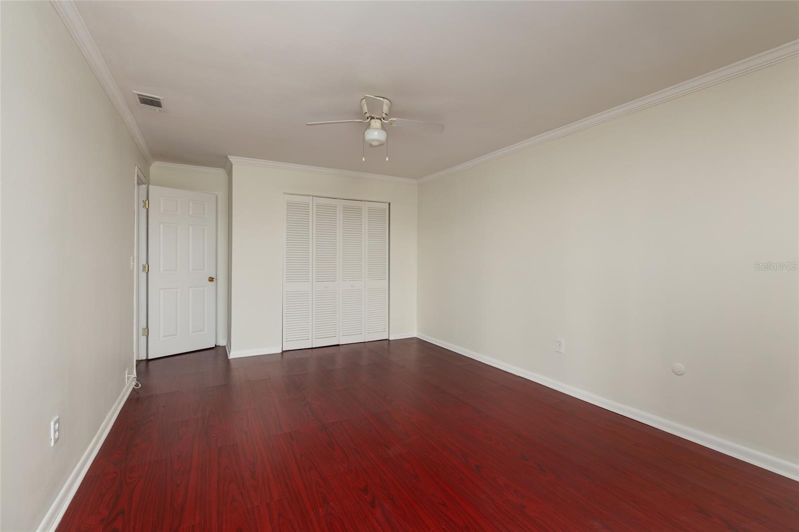 Primary Bedroom: 11' x 15'. 2 closets (other closet is behind bedroom door), Crown Molding. Laminate flooring.