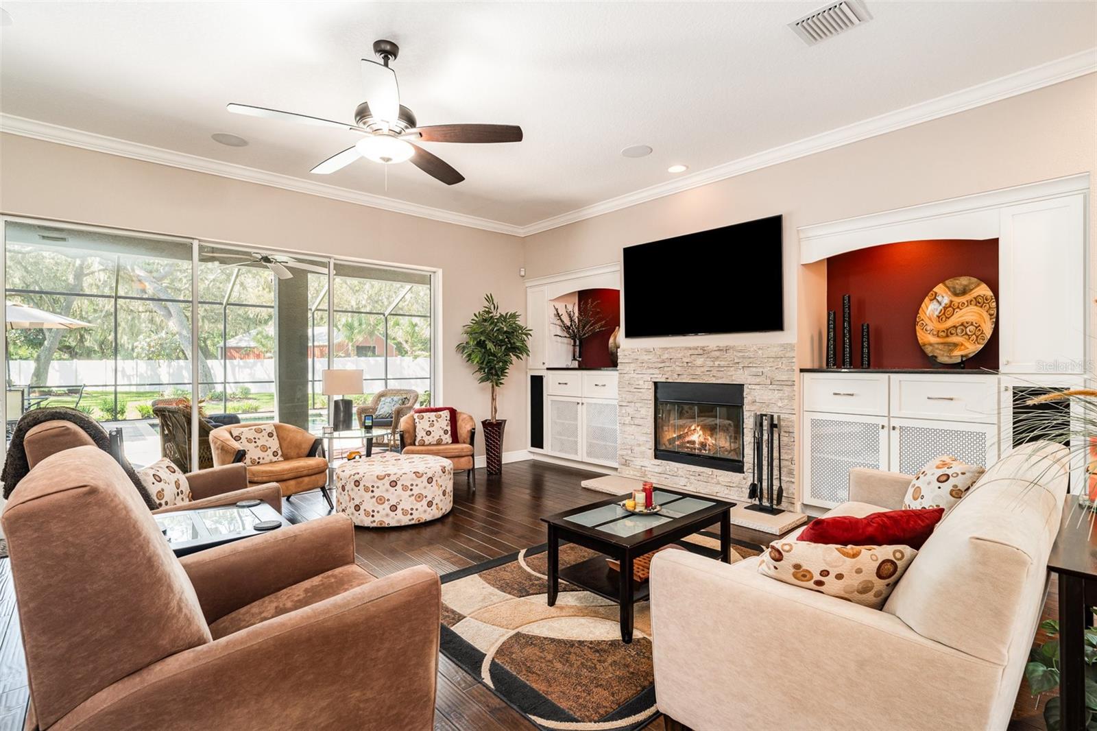 Great room with wood burning fireplace. Sliders open to pool area