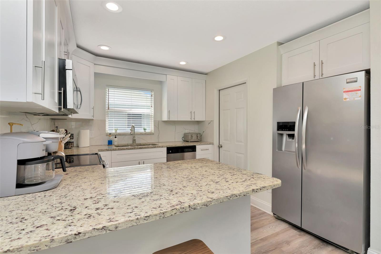 Remodeled kitchen and door to the garage- laundry and game room are in the garage.